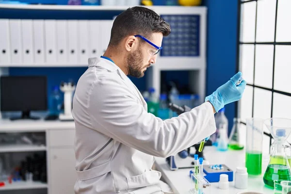 Young Hispanic Man Wearing Scientist Uniform Measuring Liquid Laboratory — Stock Photo, Image