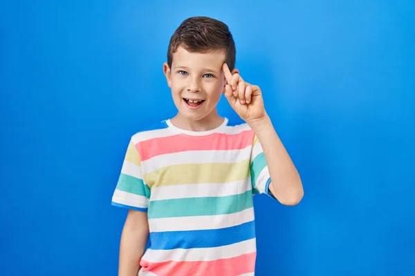 Niño Caucásico Joven Pie Sobre Fondo Azul Sonriendo Señalando Cabeza — Foto de Stock