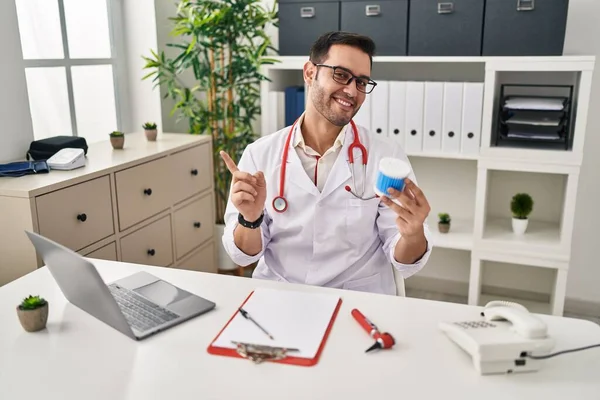 Sakallı, pamuklu sakallı, gülümseyen genç İspanyol doktor. 