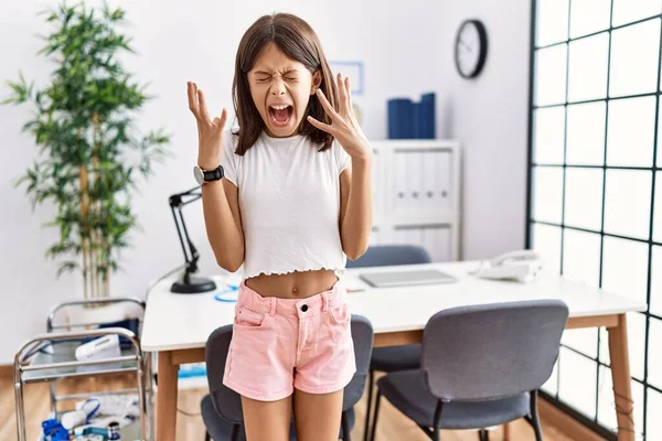 Young Hispanic Girl Standing Pediatrician Clinic Celebrating Mad Crazy Success — Photo