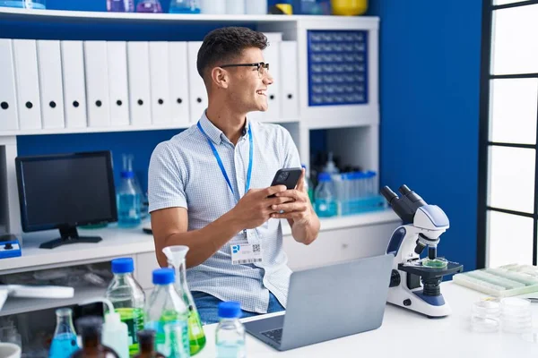 Young Hispanic Man Scientist Using Laptop Smartphone Laboratory — ストック写真