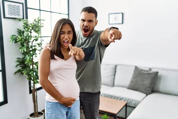 Young Interracial Couple Expecting Baby Touching Pregnant Belly Pointing Displeased — Stock Photo, Image