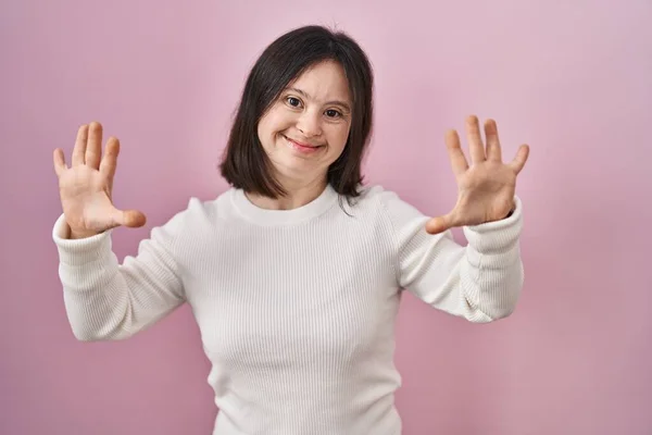 Kobieta Zespołem Downa Stoi Nad Różowym Tle Pokazując Wskazując Palcem — Zdjęcie stockowe