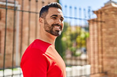 Sokakta kendinden emin gülümseyen İspanyol genç adam.