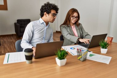 Ofiste dizüstü bilgisayarla çalışırken gülümseyen iki iş adamı..