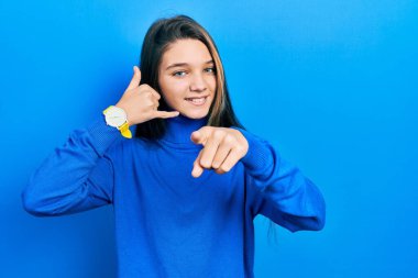 Balıkçı yaka kazak giyen genç esmer kız gülümsüyor telefonda konuşuyor ve seni işaret ediyor. Ara beni.. 