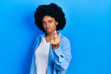 Young african american woman wearing casual clothes showing middle finger, impolite and rude fuck off expression 