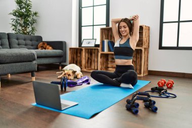 Evde esneme kursu aldığından emin bir şekilde gülümseyen genç İspanyol kadın.