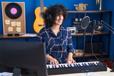 Ortadoğulu genç bir müzisyen müzik stüdyosunda piyano çalıyor.