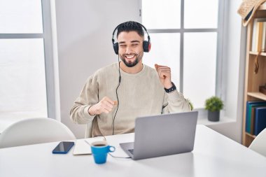 Genç Arap adam evde oturmuş müzik dinliyor.
