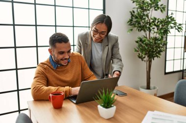 Ofiste masa başında çalışırken gülümseyen iki iş adamı..