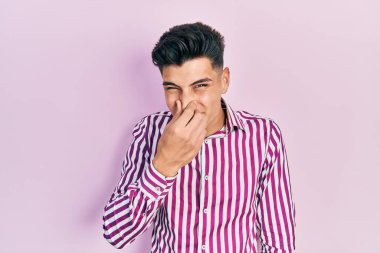 Gündelik kıyafetler giyen genç İspanyol adam pis ve iğrenç bir koku alıyor, dayanılmaz bir koku, nefesini burnunda tutuyor. Kötü kokuyor. 