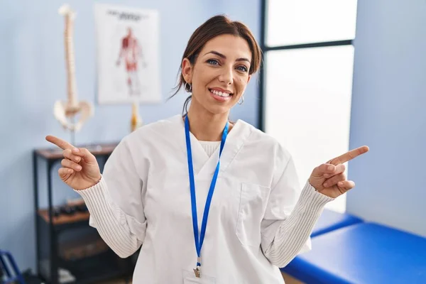 Young Brunette Woman Working Pain Recovery Clinic Smiling Confident Pointing — Photo