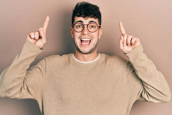 Jovem Hispânico Vestindo Roupas Casuais Óculos Sorrindo Espantado Surpreso Apontando — Fotografia de Stock
