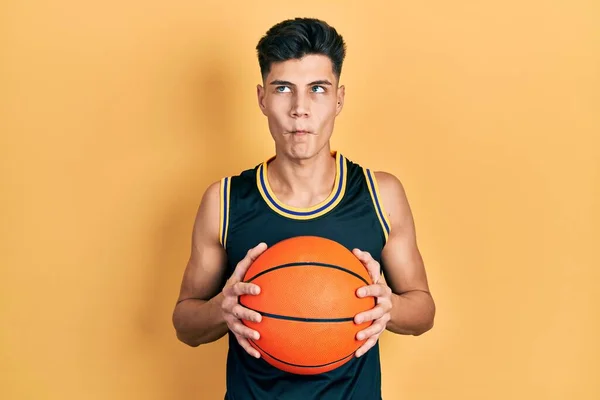 Junger Hispanischer Mann Hält Basketballball Und Macht Fischgesicht Mit Mund — Stockfoto