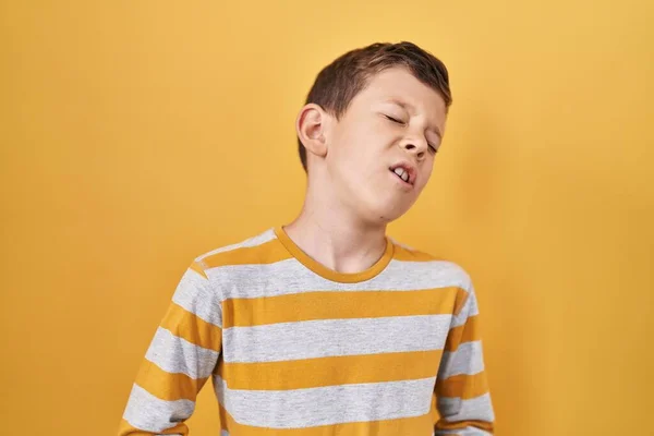 若い白人の子供が胃の上に手で黄色の背景の上に立っているので 吐き気 痛みを伴う病気の気分が悪い キャッシュ コンセプト — ストック写真
