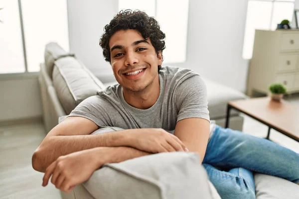 Νεαρός Ισπανόφωνος Χαμογελαστός Χαρούμενος Κάθεται Στον Καναπέ Στο Σπίτι — Φωτογραφία Αρχείου