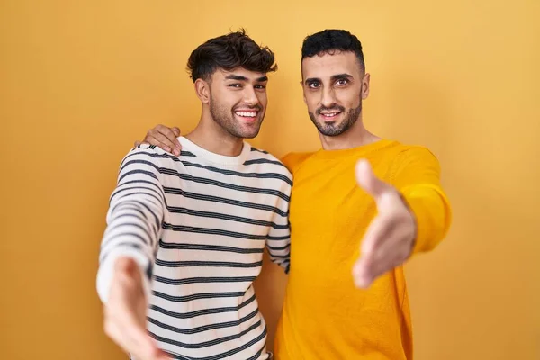 Unga Latinamerikanska Homosexuella Par Står Över Gul Bakgrund Leende Vänlig — Stockfoto