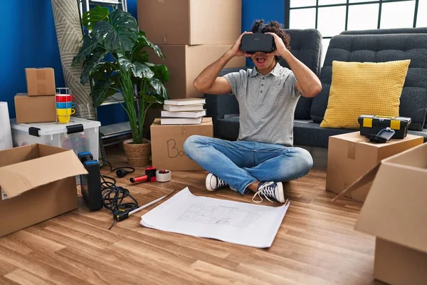 Young Hispanic Man Suprised Using Virtual Reality Glasses New Home — стоковое фото