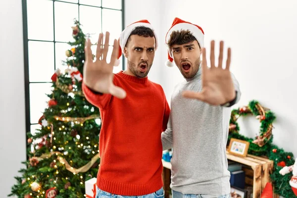 Genç Eşcinsel Çift Noel Ağacının Yanında Şapkalarını Takmış Hareketlerini Kızgın — Stok fotoğraf