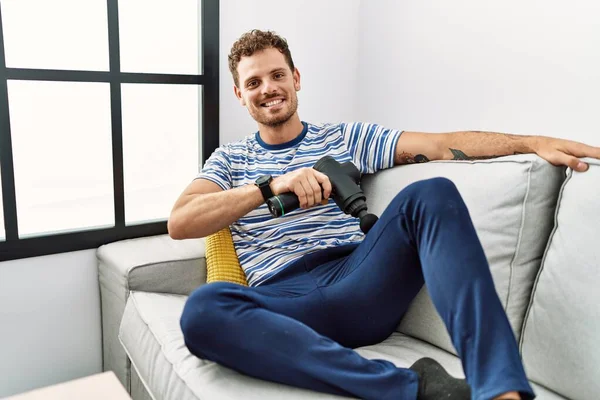 Jovem Hispânico Sorrindo Confiante Usando Pistola Percussão Casa — Fotografia de Stock