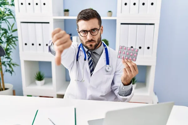 Handsome Hispanic Man Wearing Doctor Uniform Holding Prescription Pills Angry — Stock Photo, Image