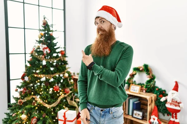 Redhead Man Long Beard Wearing Christmas Hat Christmas Tree Pointing — Stockfoto