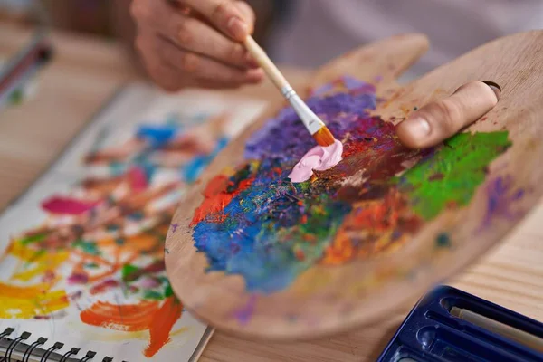 年轻的阿拉伯男子在艺术工作室的调色板上混合着色彩 — 图库照片