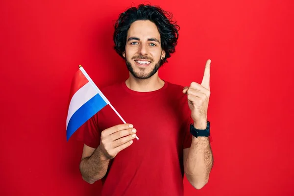 Handsome Hispanic Man Holding Netherlands Flag Smiling Idea Question Pointing — Stock Photo, Image