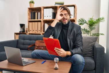 Muayenehanede çalışan yakışıklı, orta yaşlı bir adam. Şaşırmış yüzüyle, parmaklarından bakan bir jest yapıyor. İnançsız ifade. 