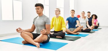 Bir grup genç, spor merkezinde yoga eğitimi alıyor..