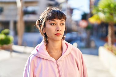 Sokakta rahat bir ifadeyle duran genç kadın.