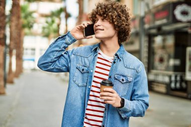 Genç İspanyol adam şehirde telefonla konuşuyor.