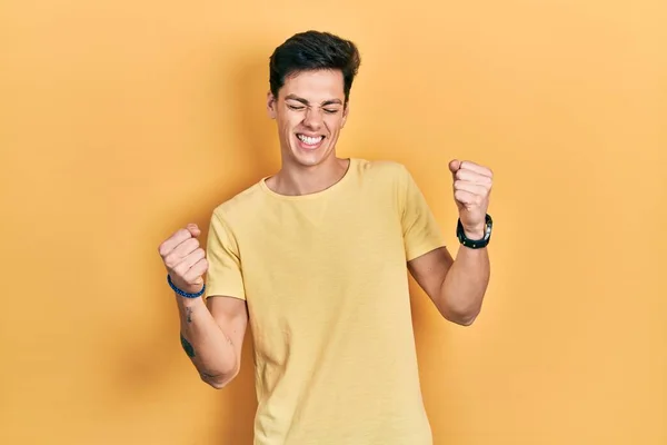 Joven Hombre Hispano Vistiendo Camiseta Amarilla Casual Muy Feliz Emocionado —  Fotos de Stock