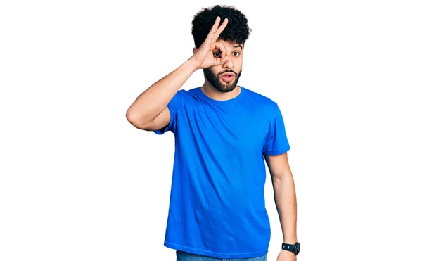 年轻的阿拉伯男子 留着胡子 穿着休闲的蓝色T恤 做着令人惊讶的手势 用惊讶的脸 用手指看着 不信的表情 — 图库照片