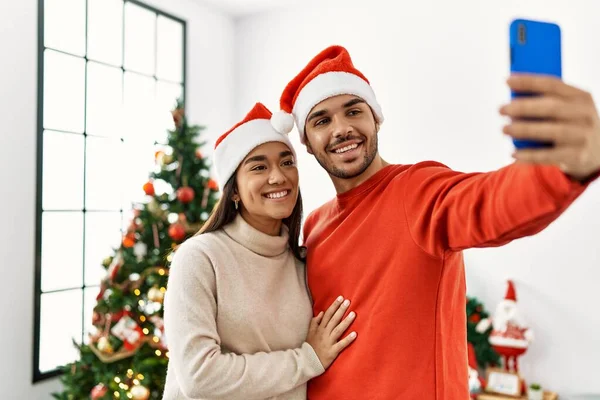 Genç Spanyol Çift Noel Şapkası Takıyor Evdeki Akıllı Telefonun Yanında — Stok fotoğraf