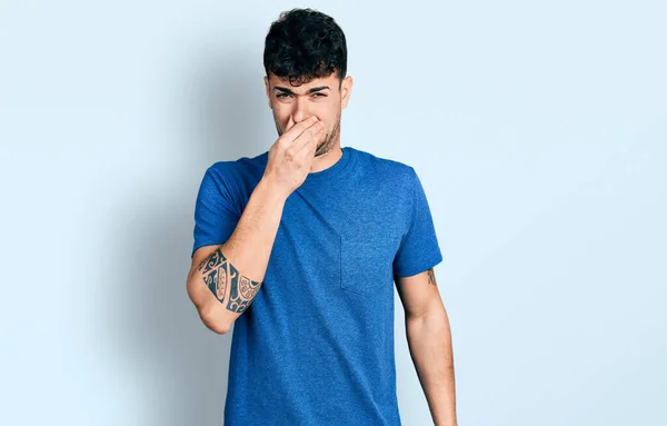 Jovem Hispânico Vestindo Camiseta Casual Cheirando Algo Fedorento Nojento Cheiro — Fotografia de Stock