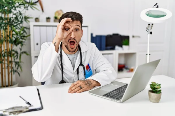 Young Doctor Working Clinic Using Computer Laptop Doing Gesture Shocked — Foto de Stock