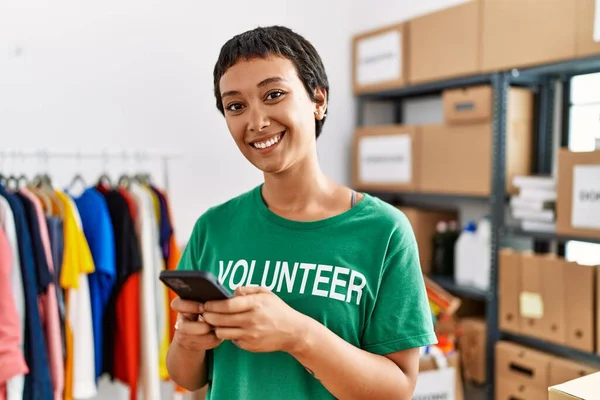 Young Hispanic Woman Wearing Volunteer Uniform Using Smartphone Charity Center — Stock Photo, Image
