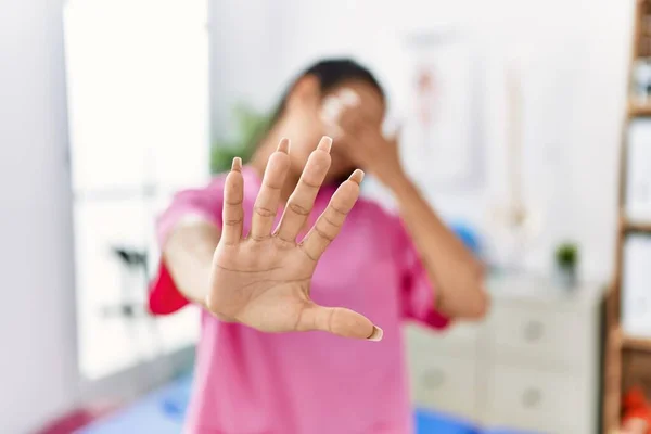 Jovem Hispânica Trabalhando Clínica Recuperação Dor Cobrindo Olhos Com Mãos — Fotografia de Stock