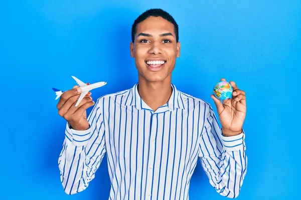 Young African American Guy Holding Paper Plane World Ball Smiling — Foto de Stock