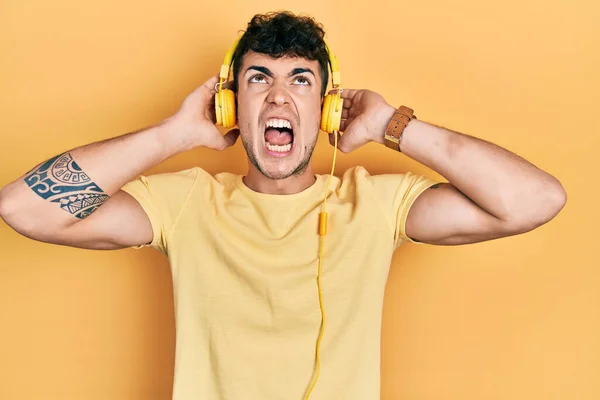 Joven Hispano Escuchando Música Usando Auriculares Enojado Loco Gritando Frustrado — Foto de Stock