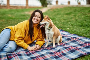 Parkta Shiba Inu köpeği olan güzel genç bir kadın.