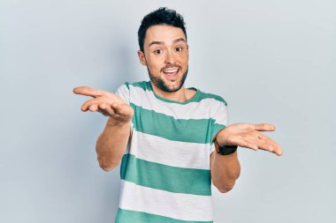 Gündelik kıyafetler giyen, neşeli gülümseyen, yardım eli uzatan ve kabullenen genç İspanyol adam.. 