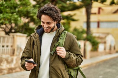Şehirde akıllı telefon kullanan yakışıklı bir İspanyol.