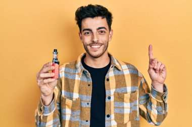 Elektronik sigara tutan genç İspanyol adam bir fikre ya da soru işaretine şaşırdı ve mutlu bir yüzle işaret etti. 