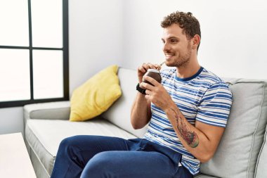 Genç İspanyol adam gülümsüyor. Evde kendine güvenen bir arkadaş.