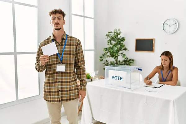 Young Handsome Man Voting Putting Envelop Ballot Box Thinking Attitude — Fotografia de Stock