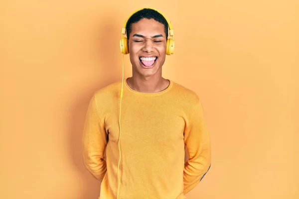 Young African American Guy Listening Music Using Headphones Sticking Tongue — Foto Stock