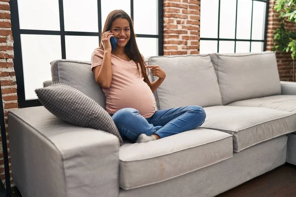 Mujer Embarazada Joven Teniendo Conversación Hablando Teléfono Inteligente Señalando Dedo —  Fotos de Stock